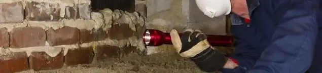 Pest control technician inspecting a crawl space for ant activity and entry points in Indianapolis, IN