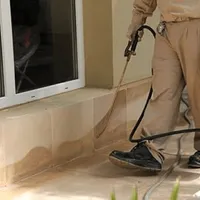 General pest control technician spraying exterior perimeter around a home in Indianapolis, IN